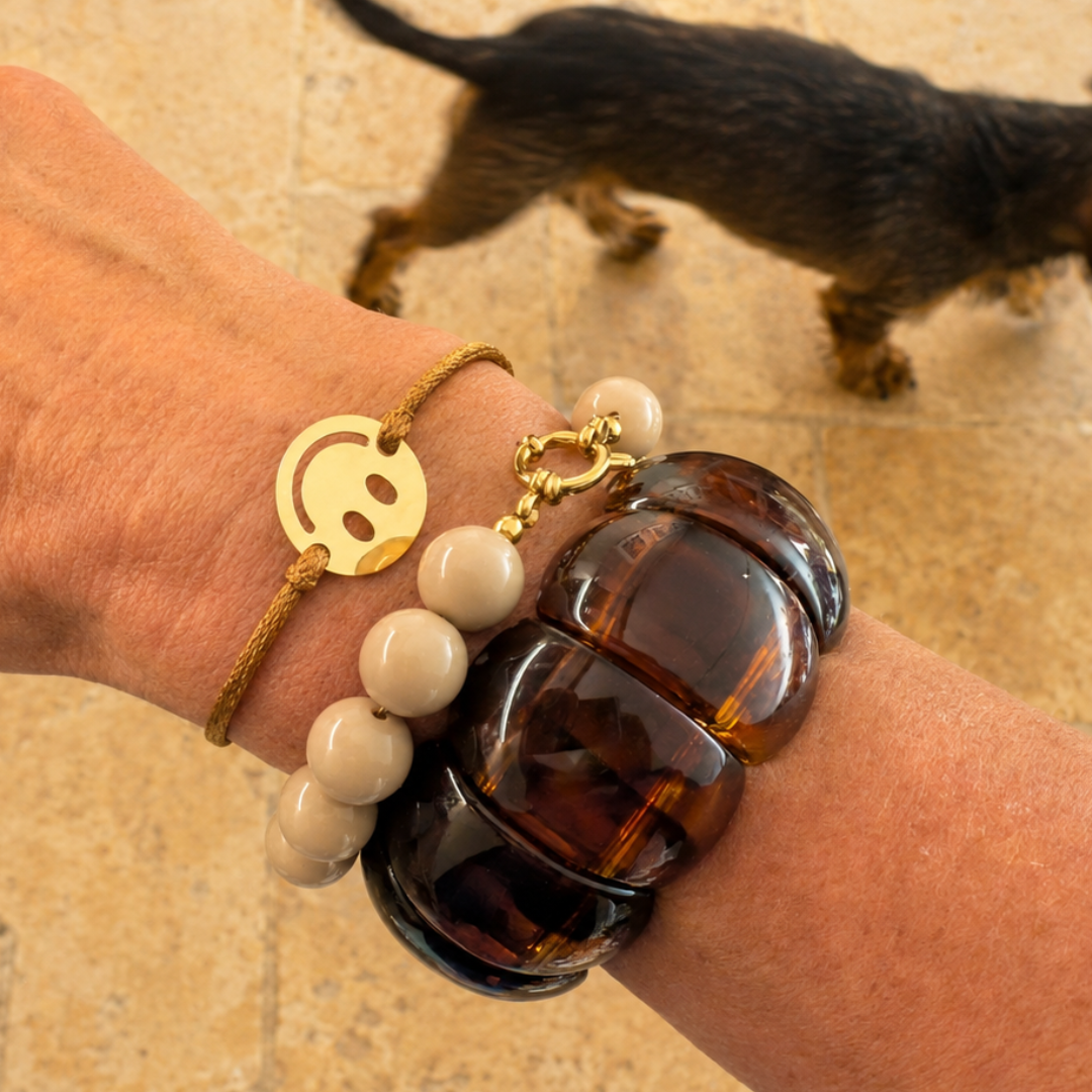 Bruine statement armbanden met grote amber kralen, beige kralen en gouden smiley armband