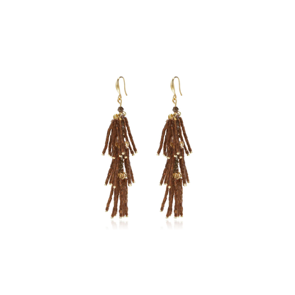 Bruine statement tassel oorbellen met lange gelaagde franjes van chocoladebruine glanzende staafkralen, gouden details en goudkleurige oorhaakjes op witte achtergrond.