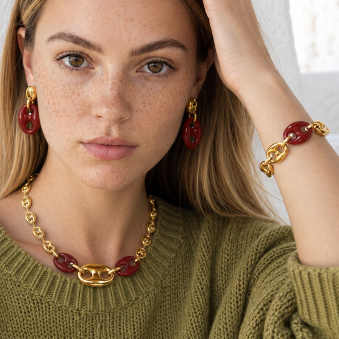 Model met burgundy bean ketting, armband en oorbellen in goud