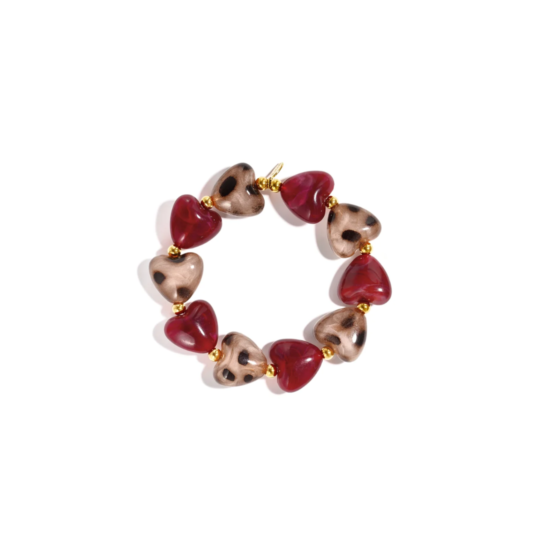 Burgundy panter hartjes kralenarmband met glanzende donkerrode hartjes, beige hartvormige kralen met bruine panterprint en gouden details