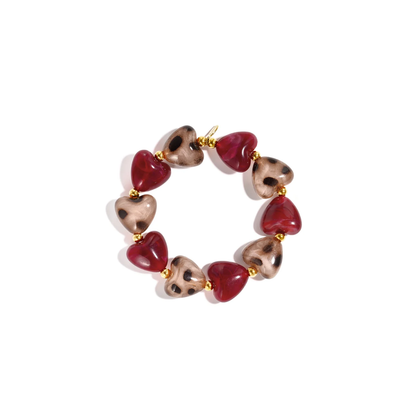 Burgundy panter hartjes kralenarmband met glanzende donkerrode hartjes, beige hartvormige kralen met bruine panterprint en gouden details