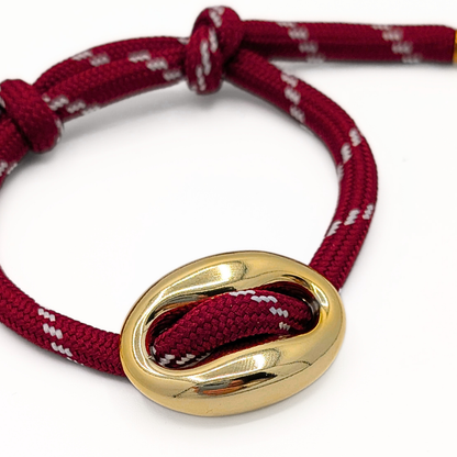 Detail van gouden varkensneus op burgundy koord armband