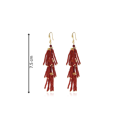 Burgundy statement tassel oorbellen met lange gelaagde franjes van glanzende rode staafkralen, kleine gouden details en goudkleurige oorhaakjes op witte achtergrond afmeting