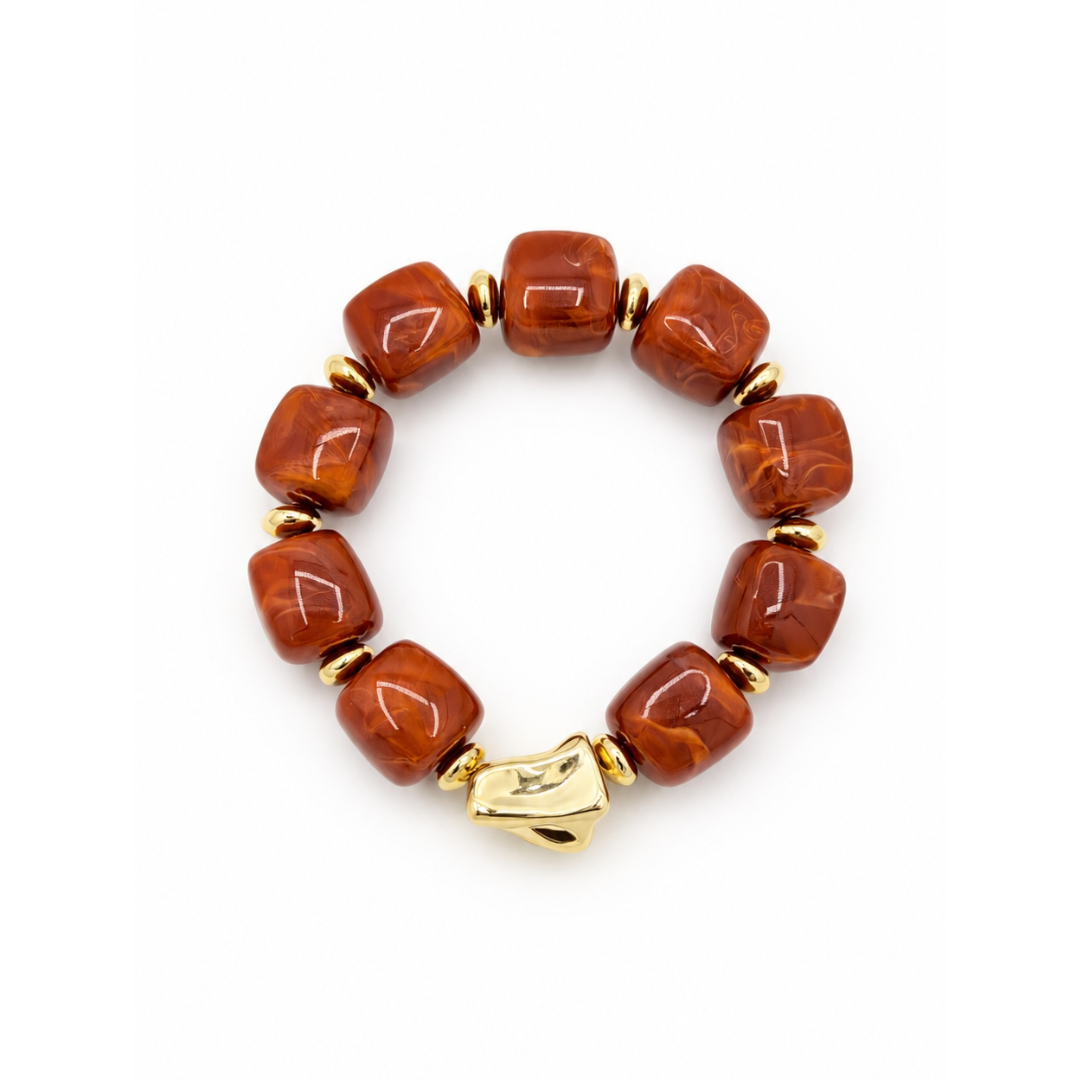 Chunky kralenarmband Marga met afgeronde hoekige kralen in burnt orange, goudkleurige tussenkralen en een organisch gevormde statement kraal.
