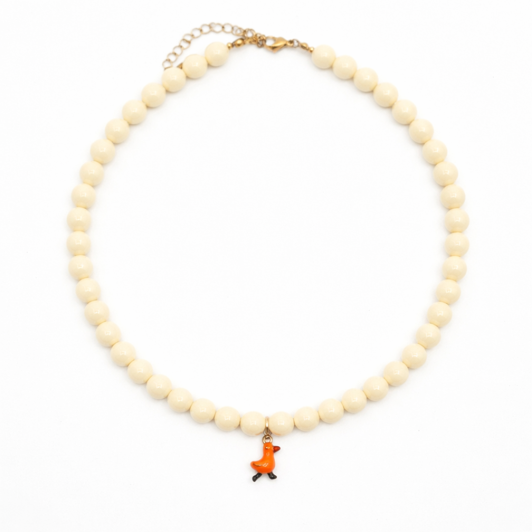 Crèmekleurige kralenketting met oranje eendje bedel van Casa Jadel
