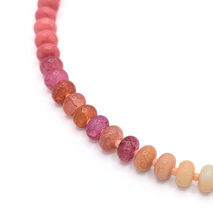 Detail van geel-roze glazen kralen met craquelé structuur in Ibiza style ketting van Jadel.