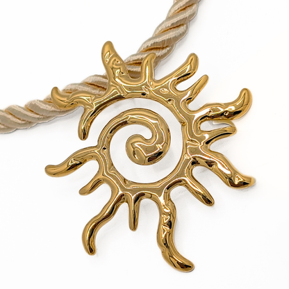 Detailfoto van grote gouden zon hanger aan naturel rope ketting
