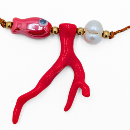 Detail van oranje rope ketting met rode koraal hanger roze zeekraal en witte parel met goudkleurige kralen van Casa Jadel