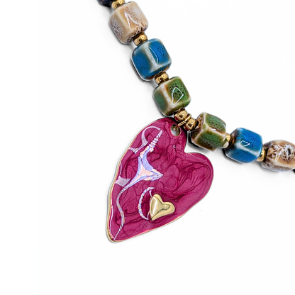 Detail van roze hart hanger met klein goud hartje
