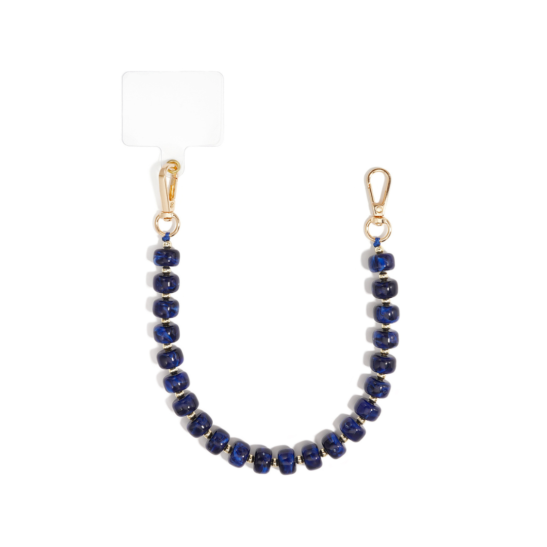 Donkerblauw chunky kralen telefoonkoord Faye met glanzende nachtblauwe en kobaltblauwe marble kralen, gouden tussenkraaltjes en karabijnsluitingen
