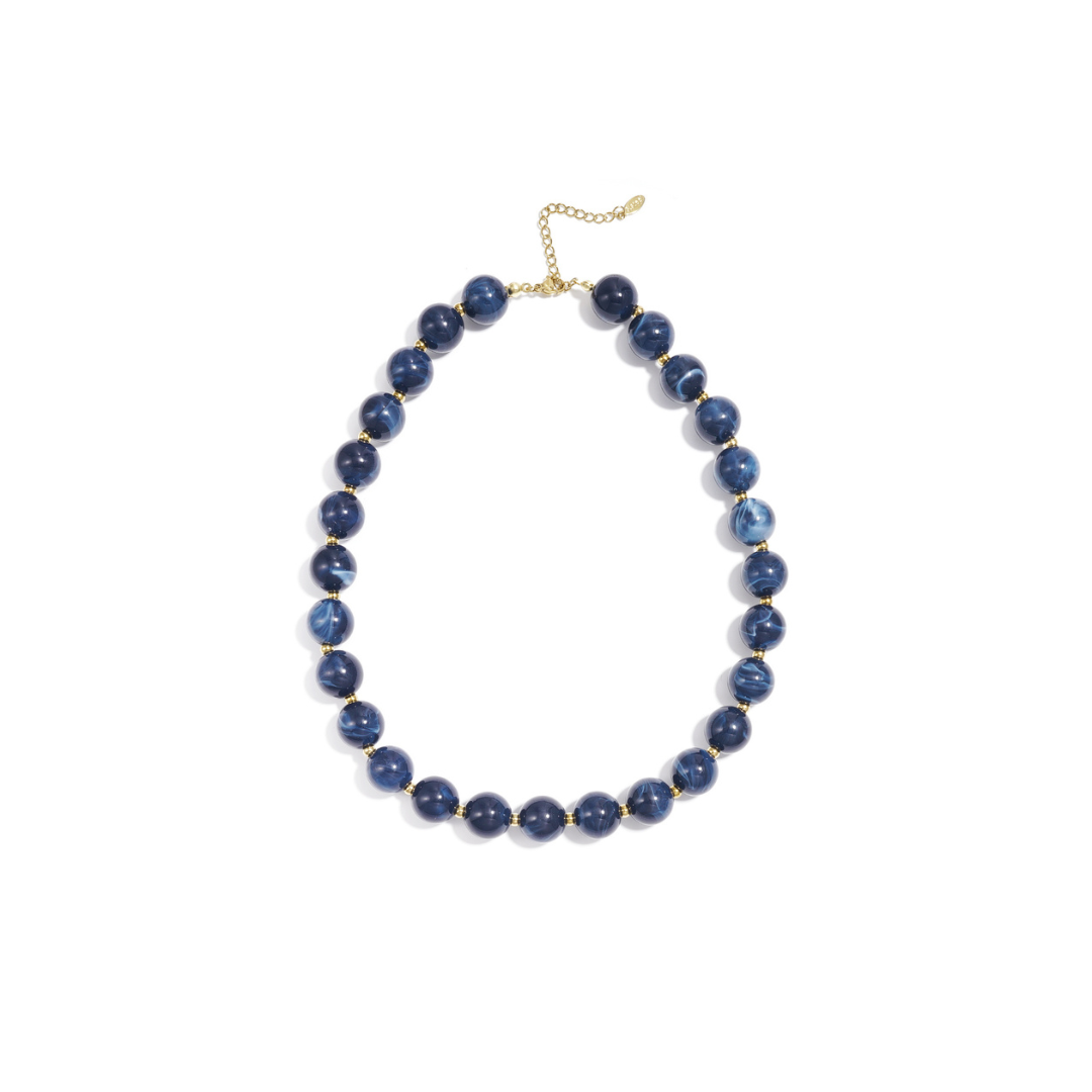 Donkerblauwe gemarmerde kralenketting met goudkleurige accenten op lichte achtergrond.