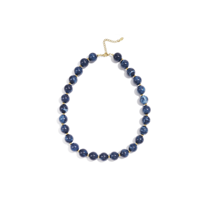 Donkerblauwe gemarmerde kralenketting met goudkleurige accenten op lichte achtergrond.