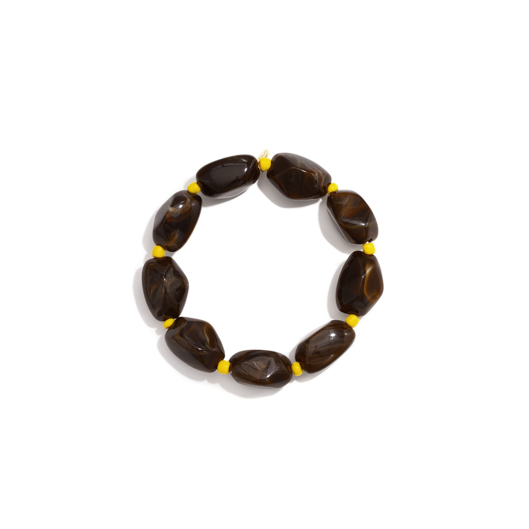 Donkerbruine marble kralenarmband met grote organische kralen en gele accenten