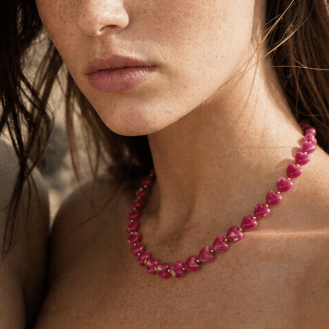 Model draagt fuchsia hartjes kralenketting van Casa Jadel