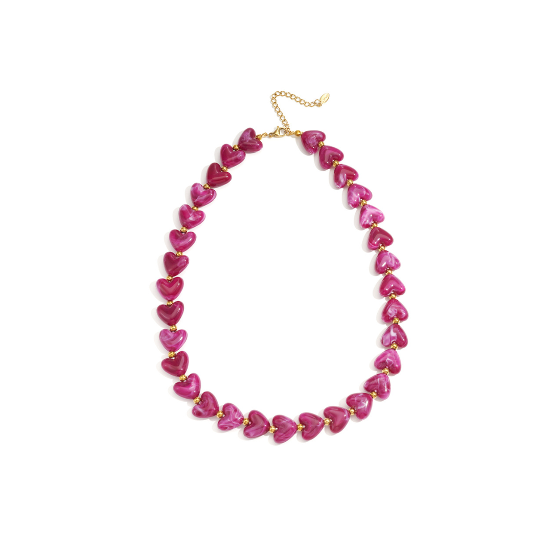 Fuchsiaroze hartjes kralenketting met glanzende kralen en goudkleurige details op witte achtergrond