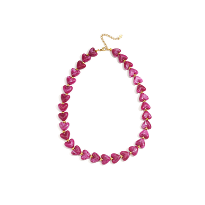 Fuchsiaroze hartjes kralenketting met glanzende kralen en goudkleurige details op witte achtergrond
