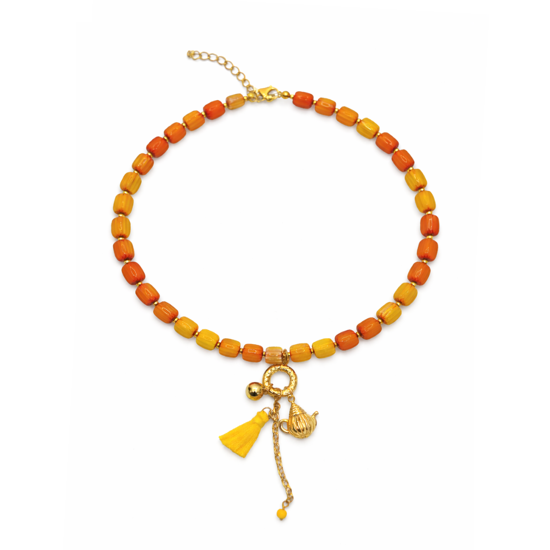 Geel oranjeglazen kralenketting dames met gouden theepot bedel en kleurrijk kwastje Ibiza stijl