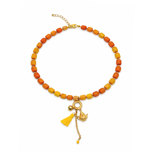 Geel oranjeglazen kralenketting dames met gouden theepot bedel en kleurrijk kwastje Ibiza stijl