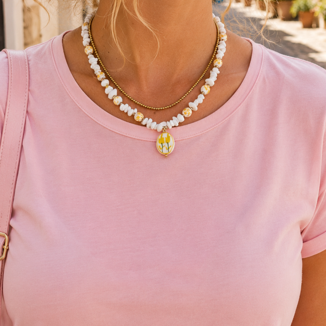 model met Geel-witte kralenketting met witte natuursteen chips, witte bloemenkralen met gele details en een handgemaakte glazen bloemetjesbedel van Casa Jadel.