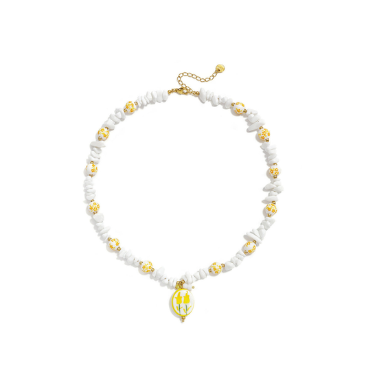 Geel-witte kralenketting met witte natuursteen chips, witte bloemenkralen met gele details en een handgemaakte glazen bloemetjesbedel van Casa Jadel.