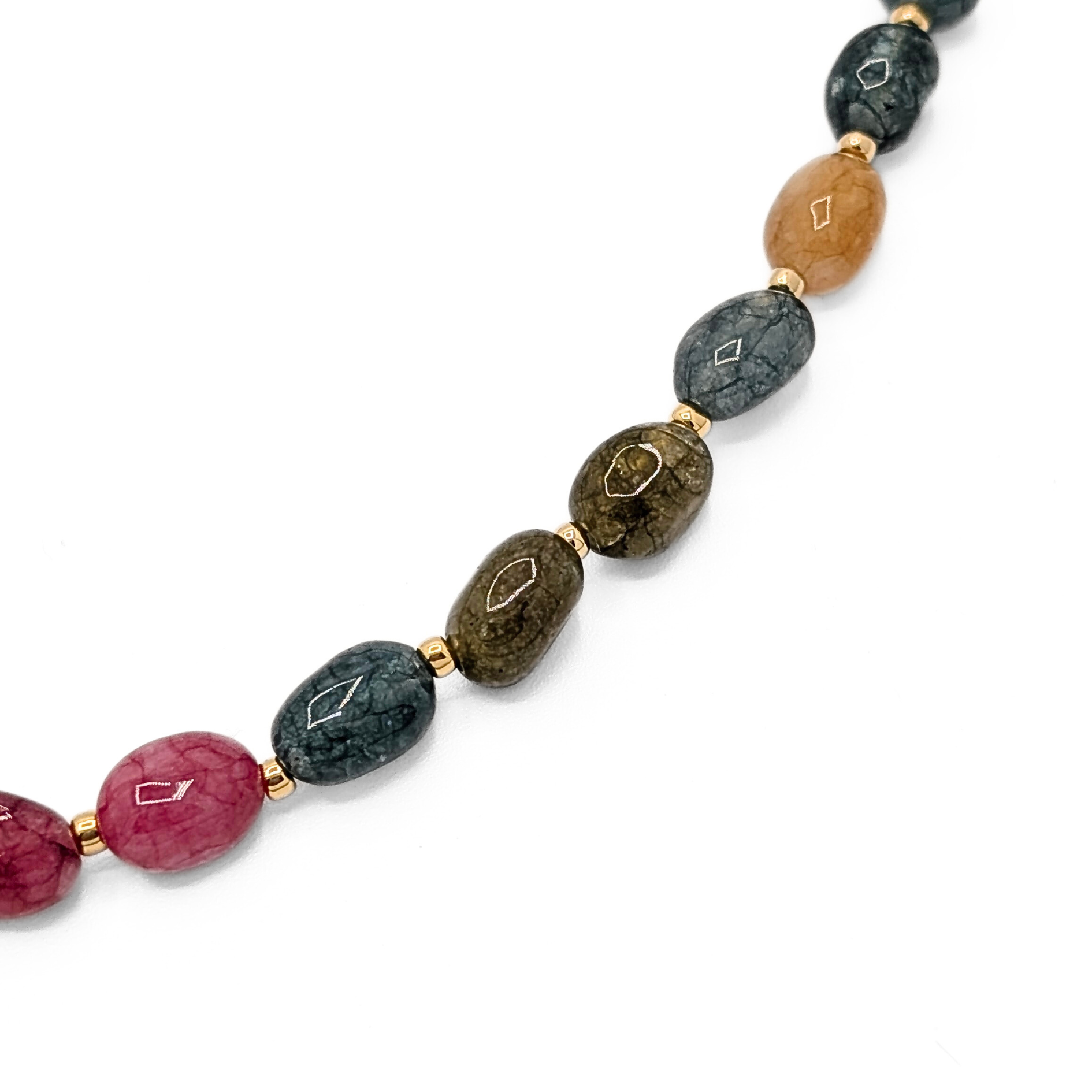 Detail van gekleurde natuursteen kralenketting met natuurlijke stenen en gouden tussenkralen