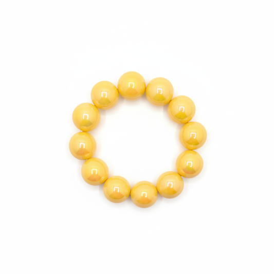 gele chunky kralenarmband met grote glanzende kralen op lichte achtergrond.