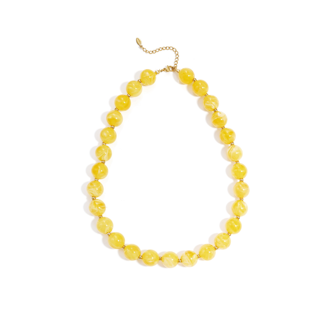 Gele gemarmerde kralenketting met goudkleurige accenten op lichte achtergrond.