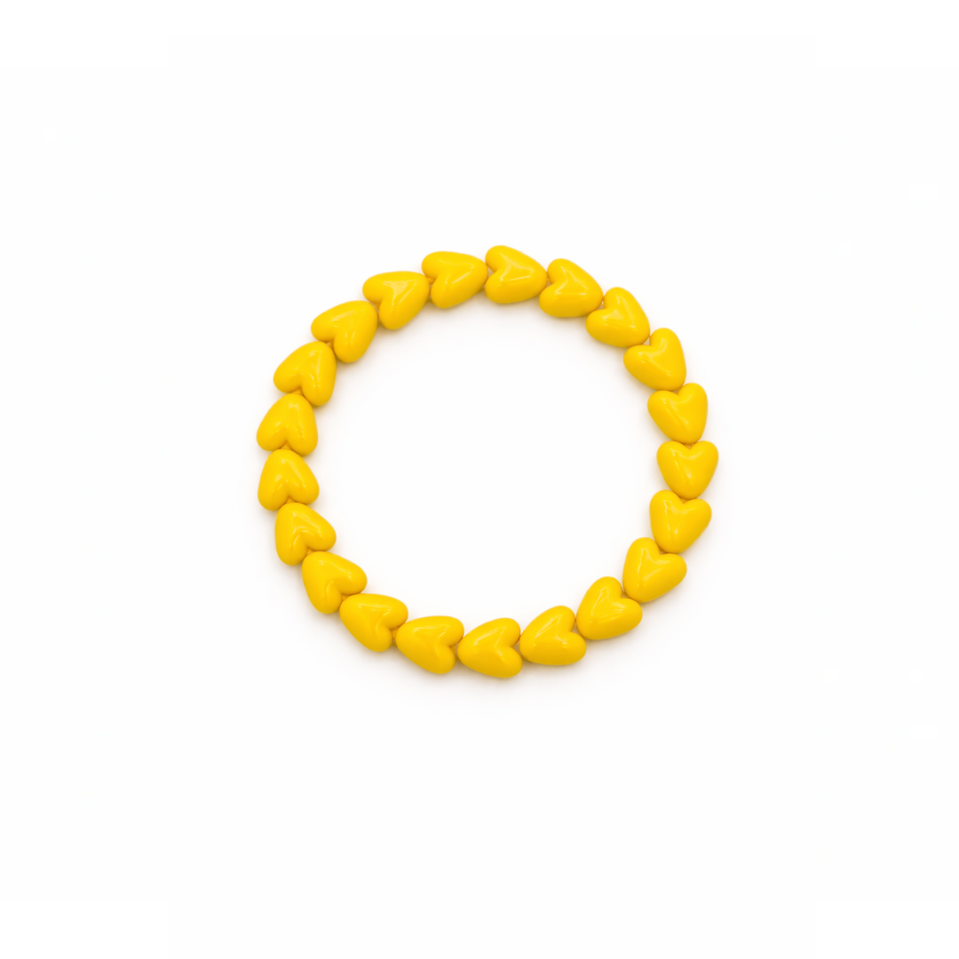 Gele hartjes kralenarmband met glanzende hartvormige kralen op witte achtergrond.