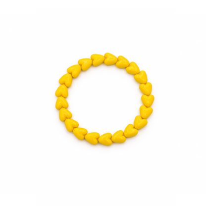 Gele hartjes kralenarmband met glanzende hartvormige kralen op witte achtergrond.