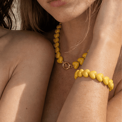 Model draagt gele hartjes kralenketting en armband van Casa Jadel