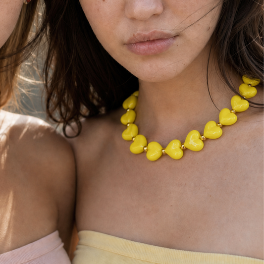 Model draagt een gele hartjesketting van Casa Jadel