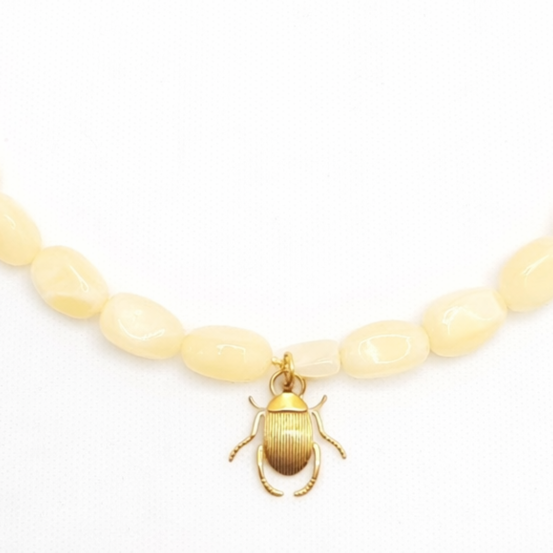 Inzoom lichtgele kralenketting met goudkleurige scarabee bedel in Ibiza style van Casa Jadel