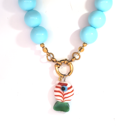 Glazen witte guppie bedel gedragen aan een kralenketting met boeislot, zomerse Ibiza-style sieraden van Jadel.