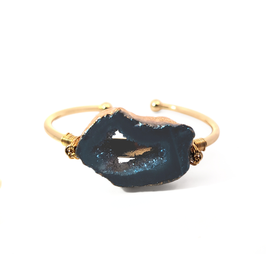 Gouden open bangle met donkergrijze agaat edelsteen en ruwe kristalstructuur