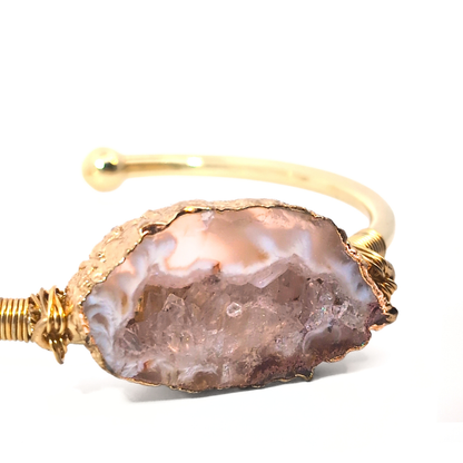 Detail van lichtroze agaat edelsteen in gouden bangle