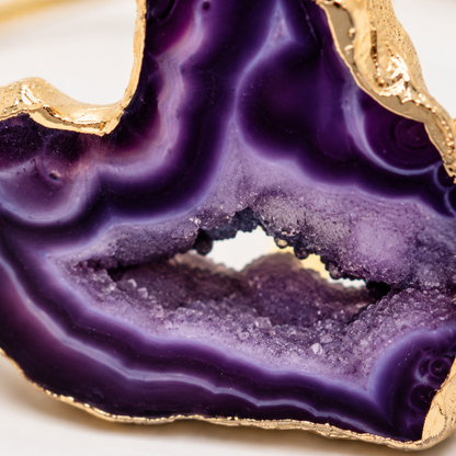 inzoom Gouden bangle met paarse amethist natuursteen en luxe goudkleurige afwerking op witte achtergrond