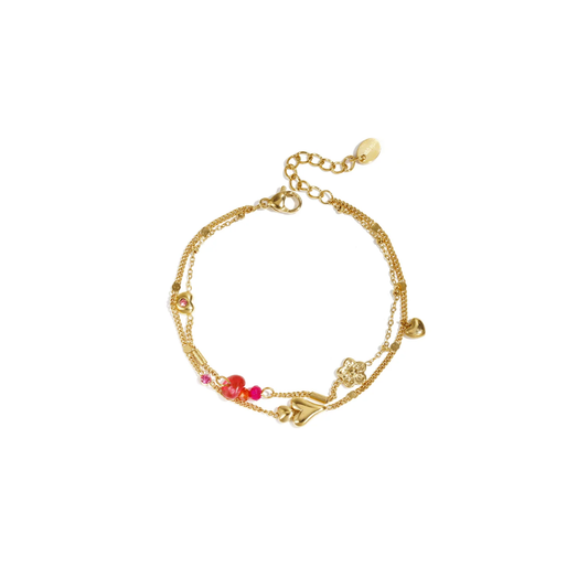 Gouden dubbele armband van stainless steel met hartjes, bloemetje en roze kralen.