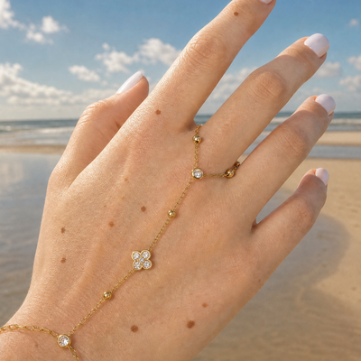 Gouden hand chain armband met ring strass clover
