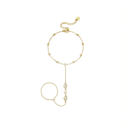 Gouden hand chain armband met ring en druppelvormige steentjes verbonden met fijne schakels