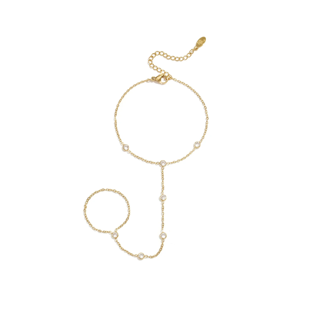 Gouden handchain armband met ring en fonkelende ronde zirkonia steentjes op witte achtergrond