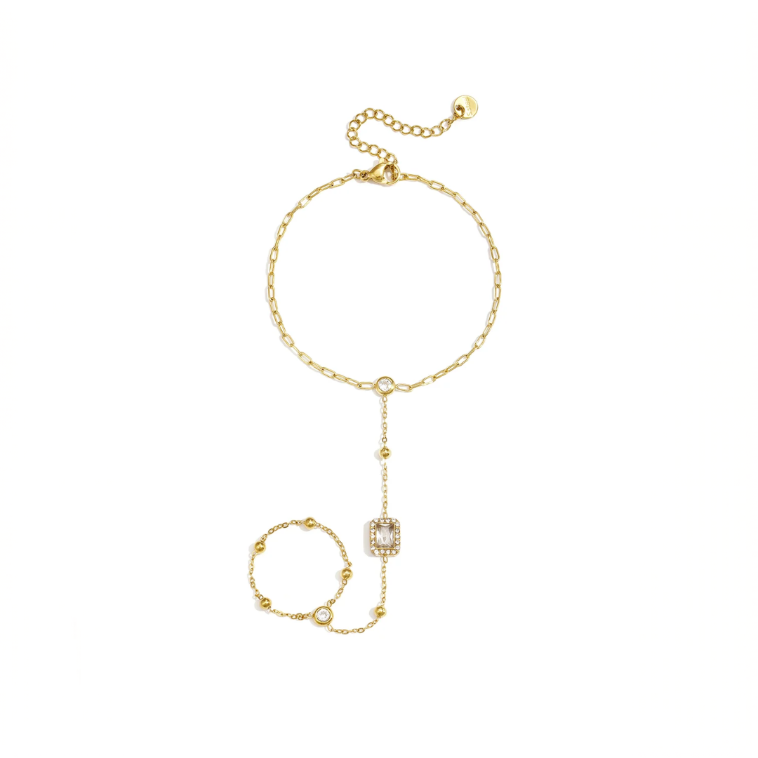 Gouden handchain armband met ring en rechthoekige steen verbonden met fijne schakels