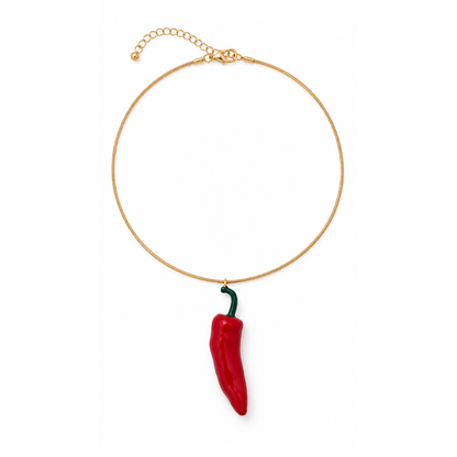 Gouden ketting met statement rode Spaanse peper hanger en verlengkettinkje op een witte achtergrond.