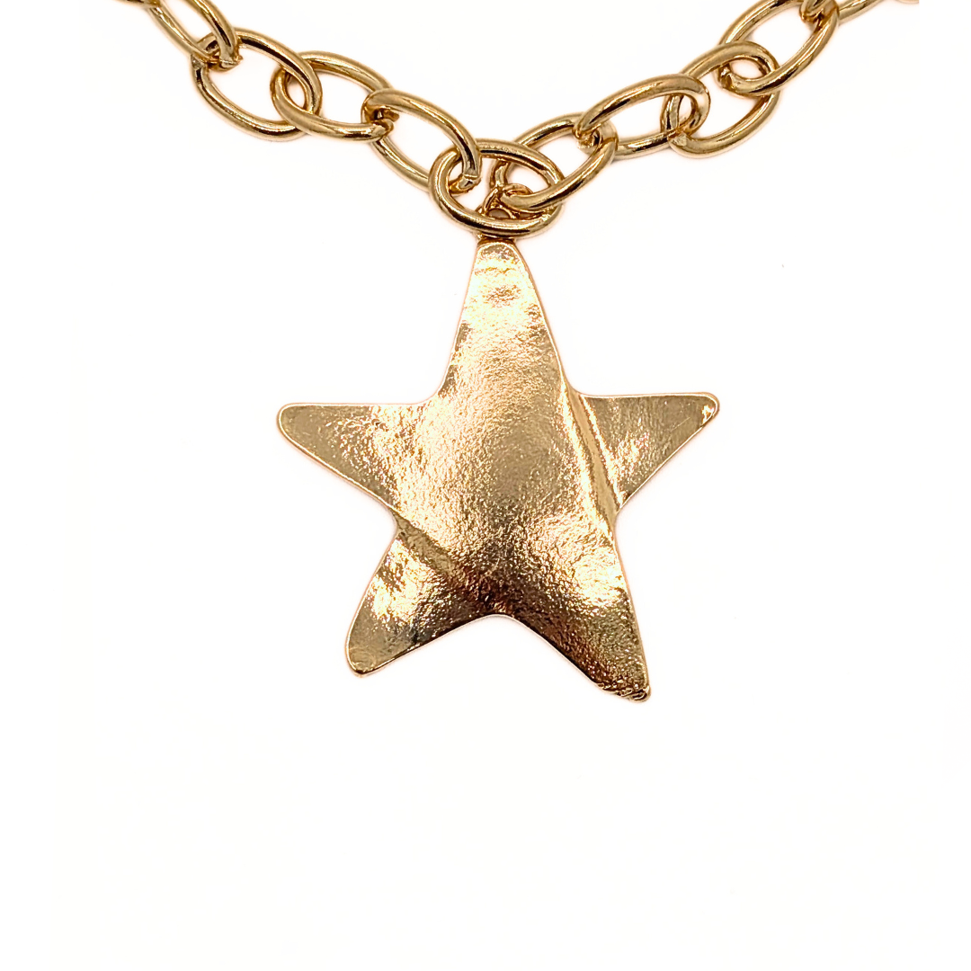 Detail van gouden ster hanger aan schakelketting