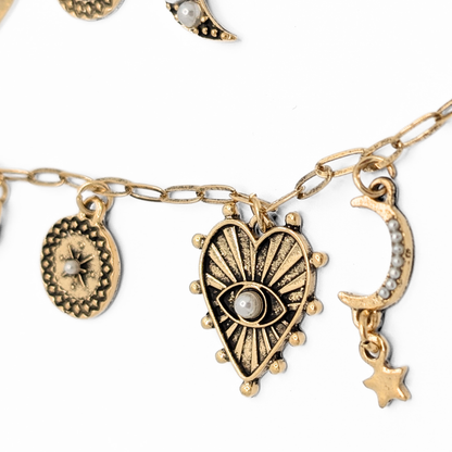 Detail van gouden ketting met hart en oog symbool Casa Jadel