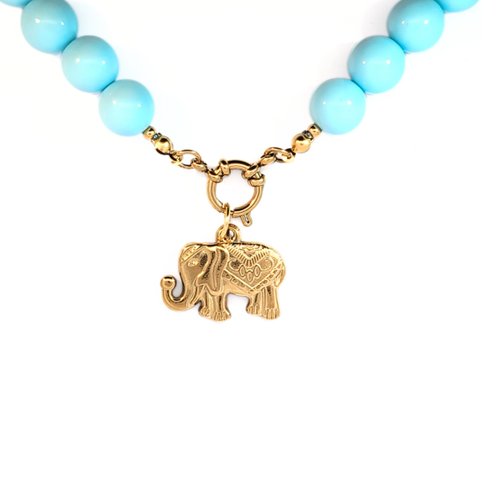 Gouden olifant bedel vooraanzicht Casa Jadel aan lichtblauwe kralenketting met boeislot.
