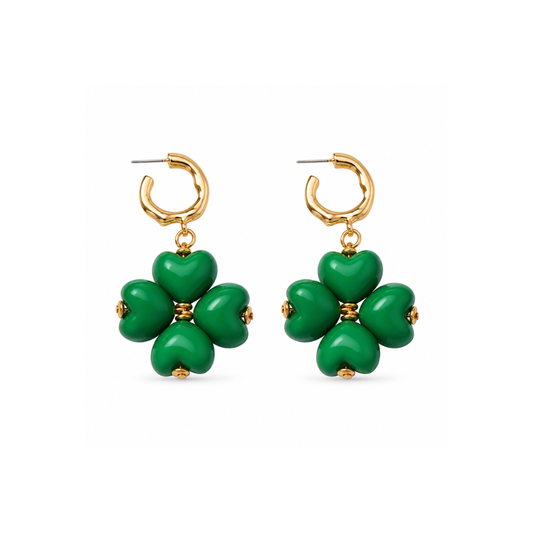 Gouden oorringetjes met een klavertje van vier glanzende groene hartjes en kleine goudkleurige kraaltjes op een witte achtergrond.