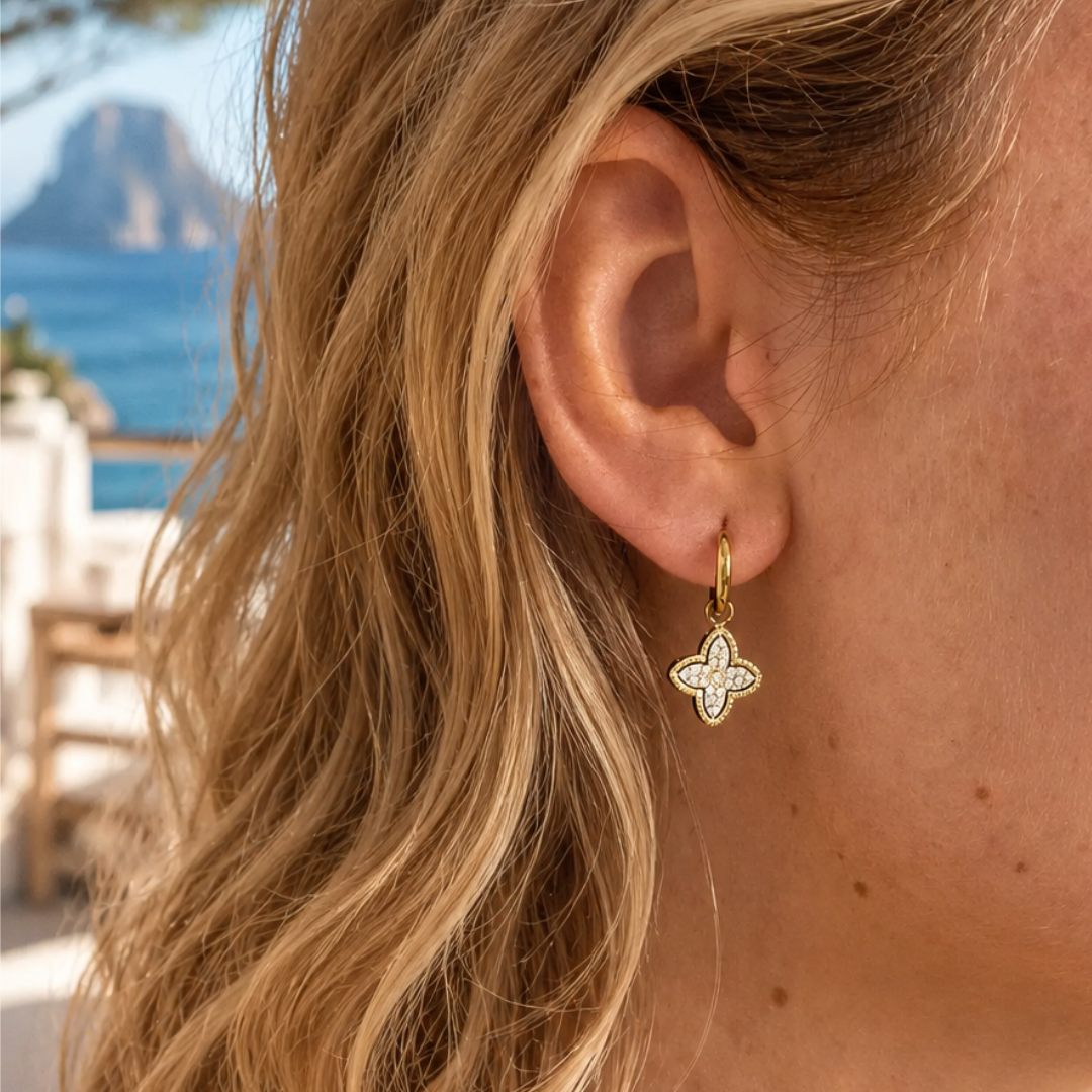 model met Gouden oorringetjes met klaverhanger bezet met fonkelende strass steentjes