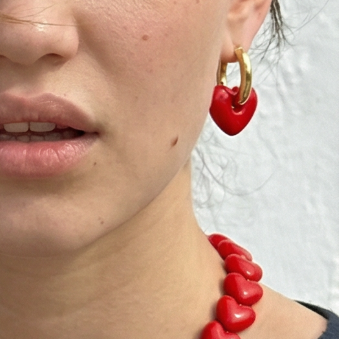 Model met Gouden oorringen beau dames met rood hartje oorbellen