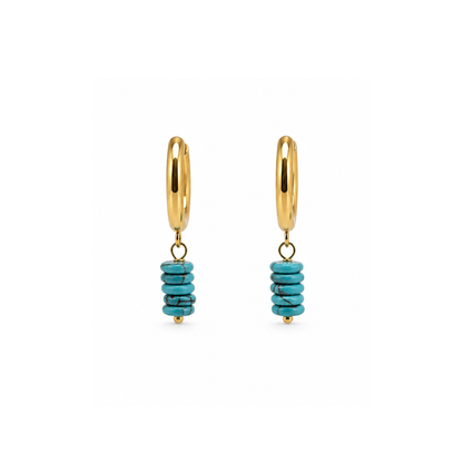 Gouden oorringen met turquoise natuursteen kralen en goudkleurige details op witte achtergrond