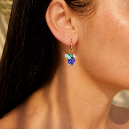 model met Gouden oorringetjes met blauwe schildpad bedel, turquoise kralen en parelaccent van Casa Jadel.